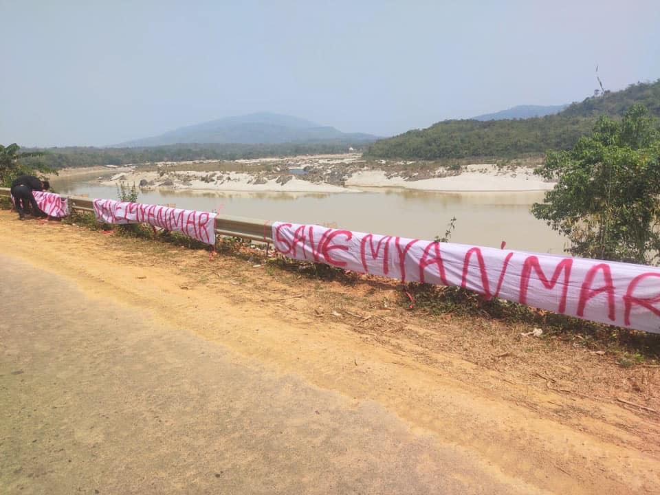 မြစ်ဆုံ view point တွင် Save Myanmar (မြန်မာပြည်ကိုကယ်တင်ပါ) စာတန်းချိတ်ဆွဲထား
